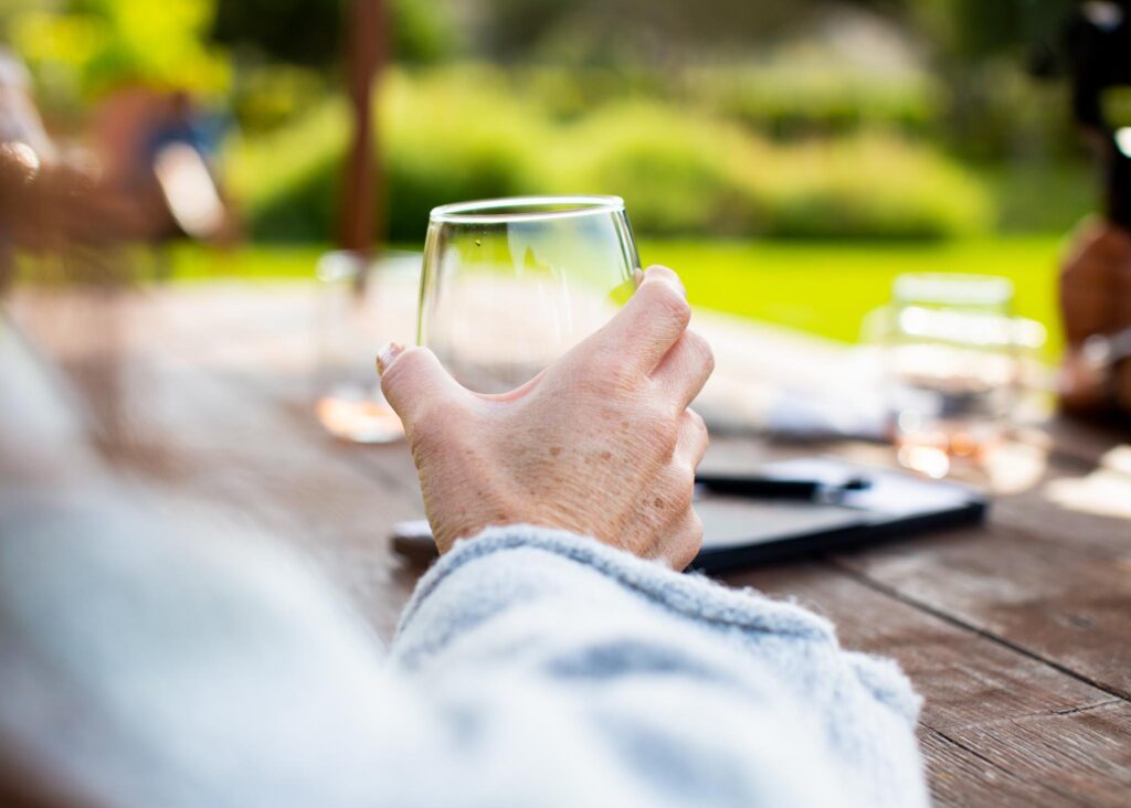 Woman's hand holding a wine glass at Stolo Famiily Winery in Cambria, California