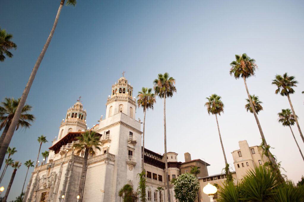 A building with palm trees, specifically at Hearst Castle.
