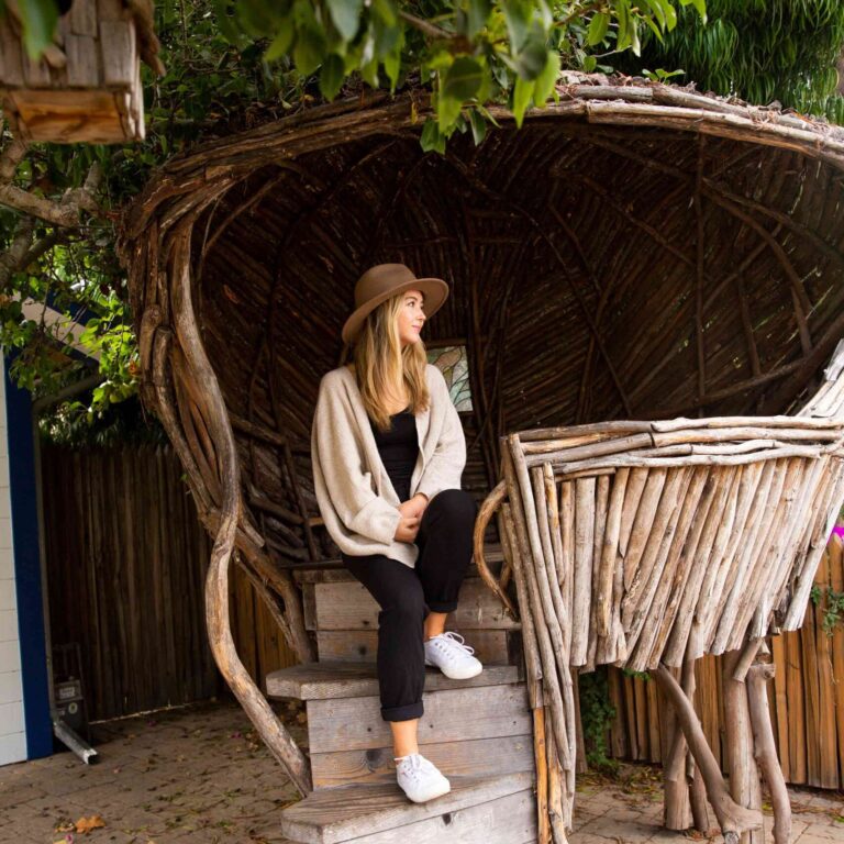 Woman Sitting Inside a Wooden Nest Sculpture